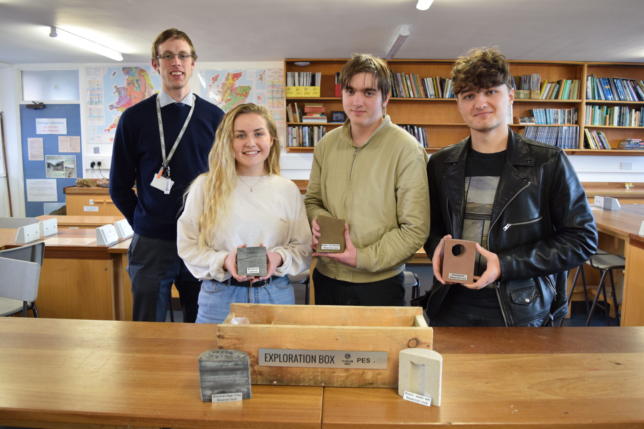 Geology teacher and three students with core samples donated to the College.