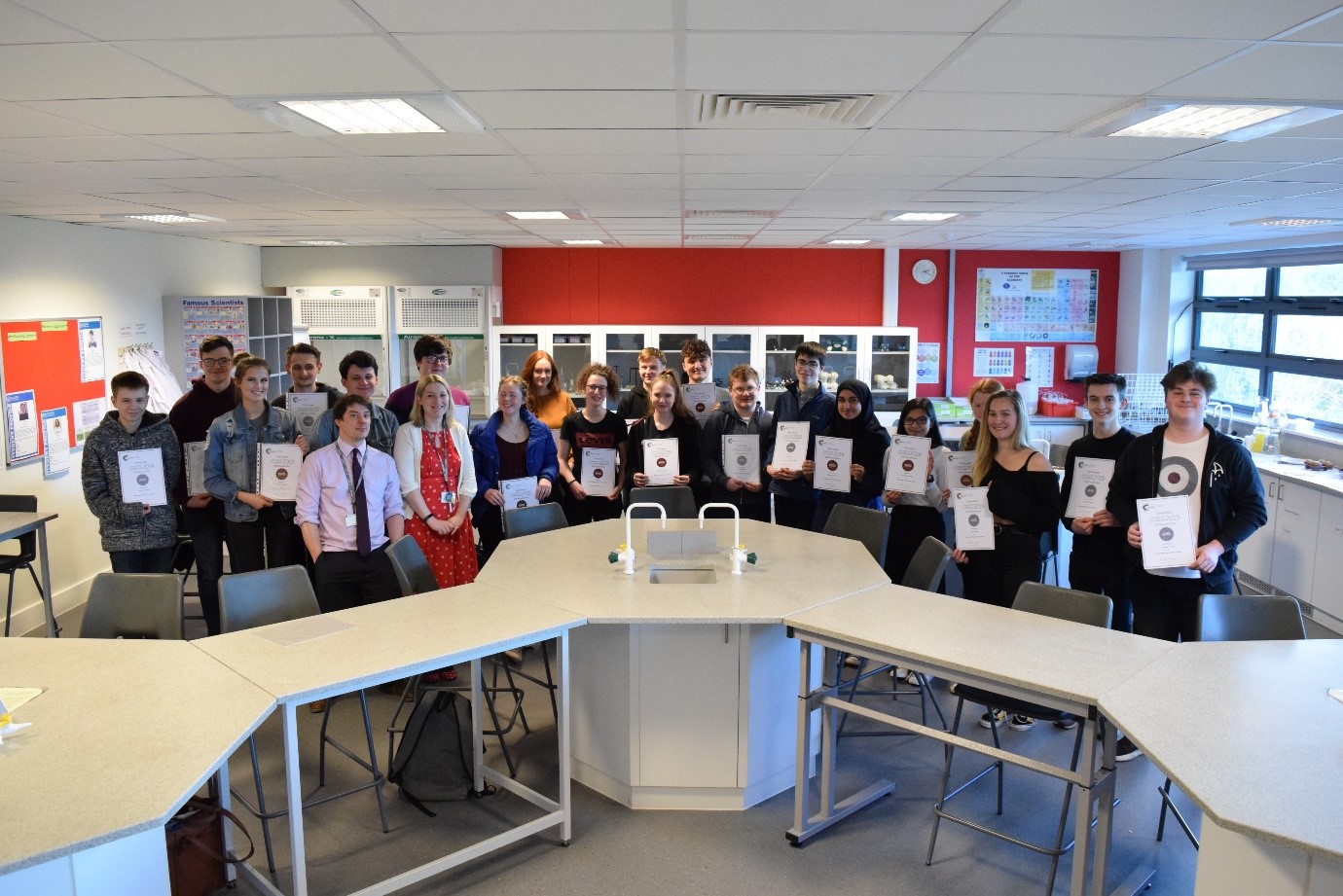 Chemistry students in lab with Olympiad certificates