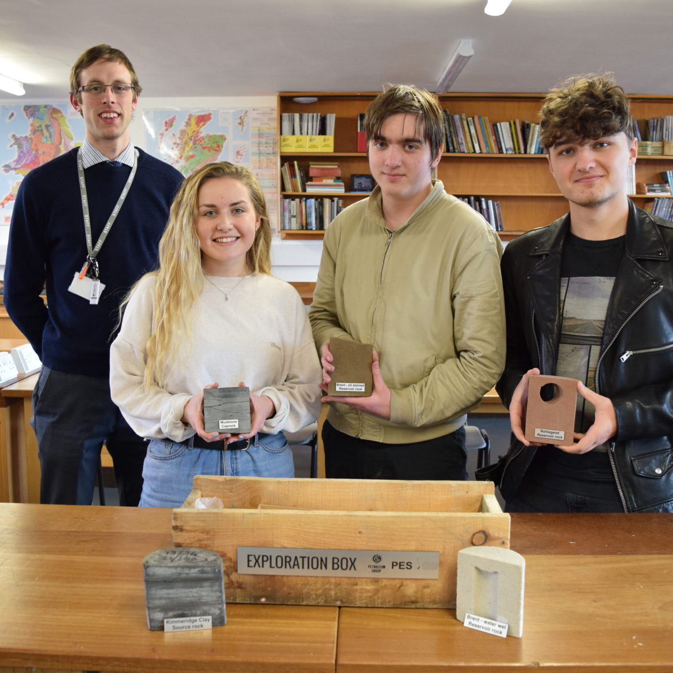 Geology teacher and three students with core samples donated to the College.